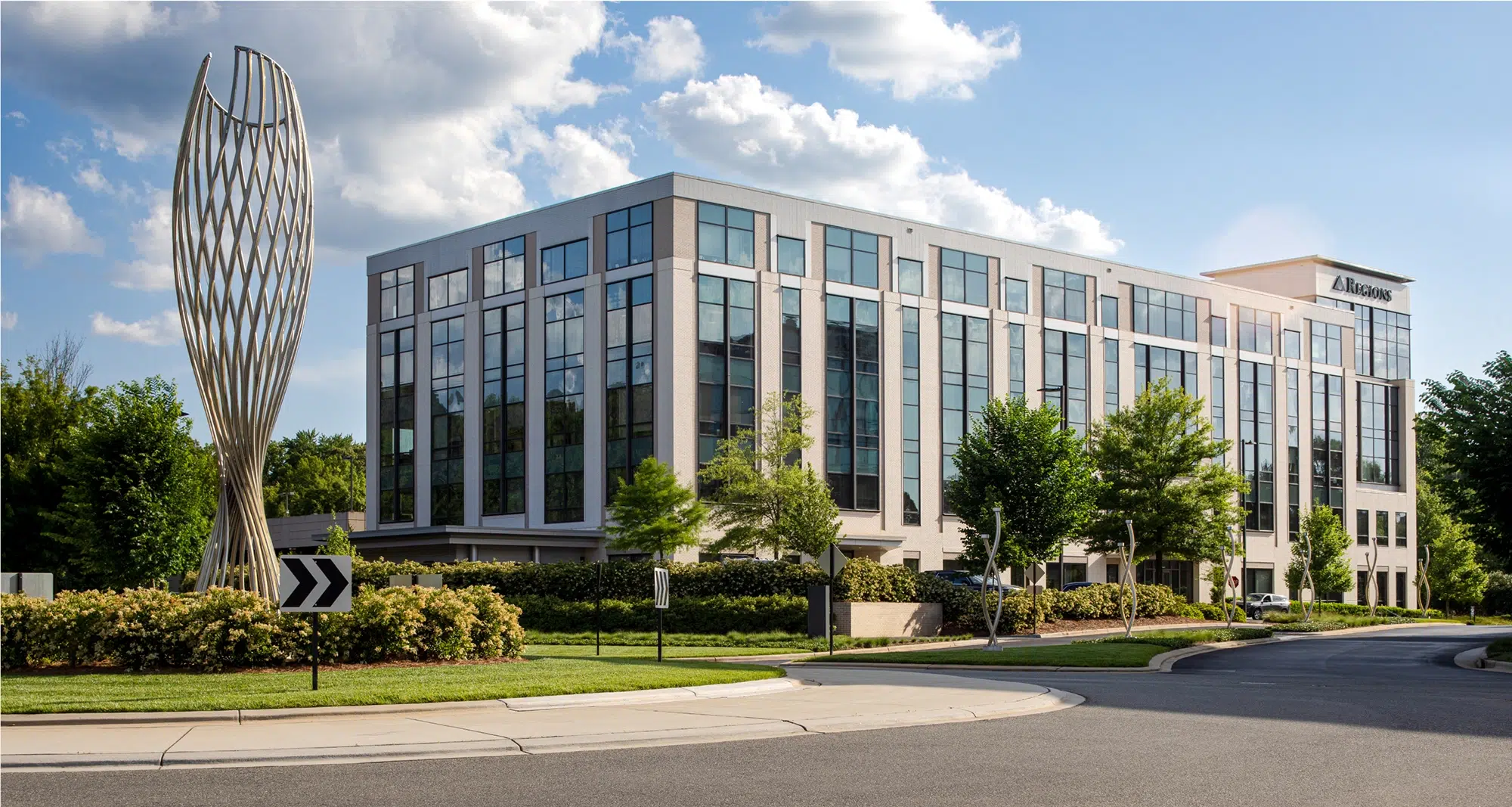 Contemporary office building with a striking metal sculpture near the entrance on the roundabout
